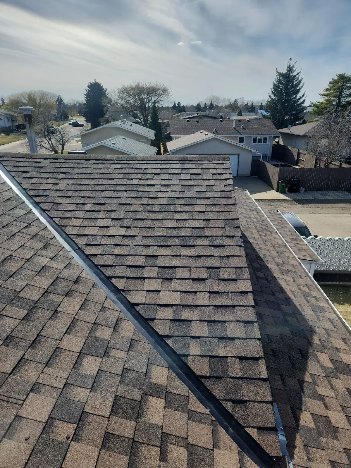 Golden hour ridge view of a finished architectural shingle roof
