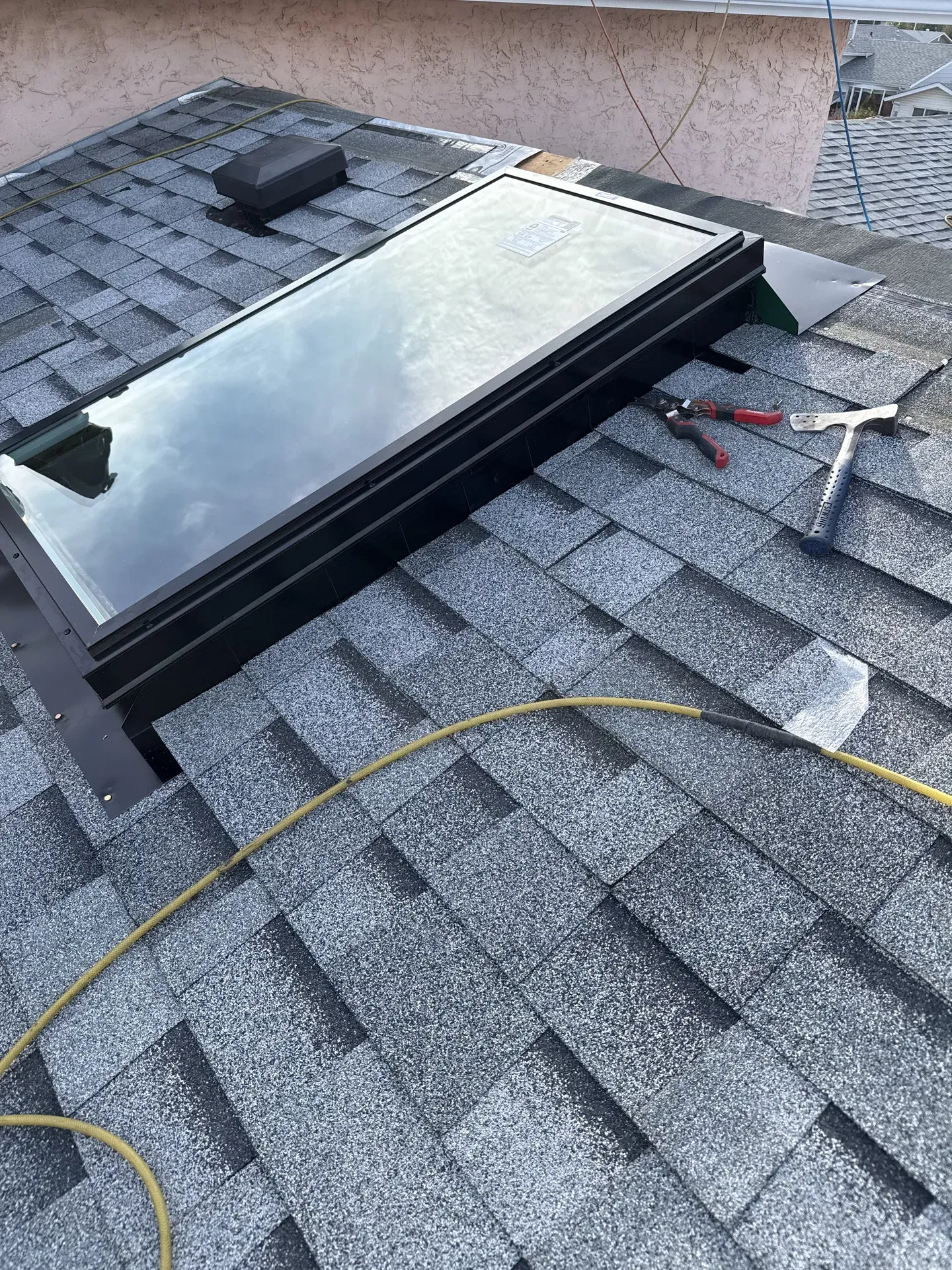 Skylight install in progress with tools on the roof